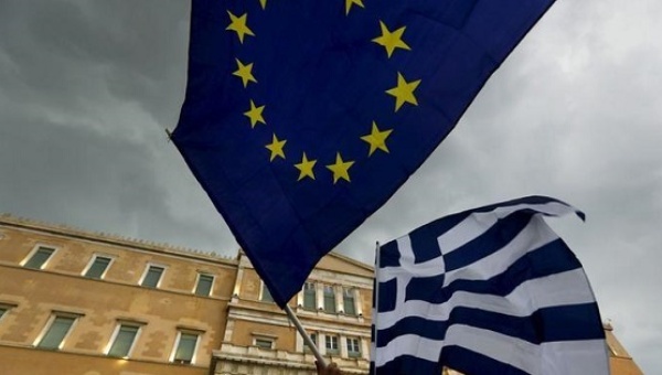 Protesters-wave-Greek-and-EU-flags-in-front-of-the-parliament-building-in-Athens-Greece-on-June-30-2015-Reuters